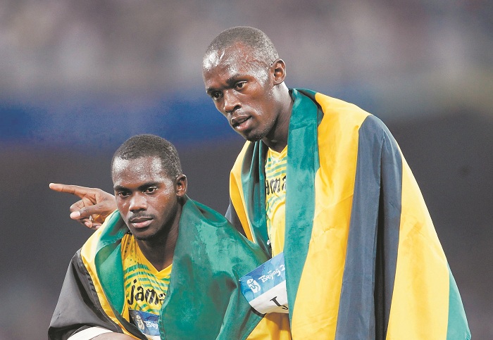 Nesta Carter, junto a Usain Bolt, intenta revertir la decisión de quitarle el oro de 4x100 al equipo jamaicano de Pekín 2008 por su positivo en una prueba reciente. LA PRENSA/AFP/Olivier MORIN