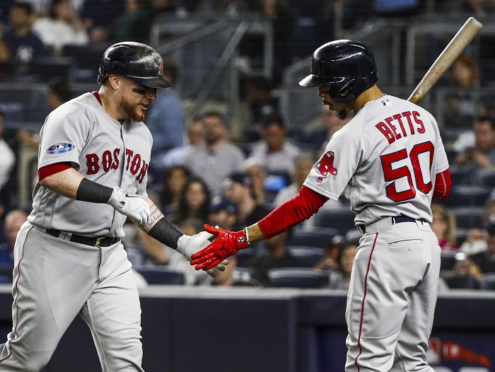 El receptor puertorriqueño de los Medias Rojas, Christian Vazquez (i), celebra con el jardinero derecho Mookie Betts (d) tras batear un jonrón durante la cuarta entrada del cuarto juego de la Serie de División de la Liga Americana de Grandes Ligas, entre los Medias Rojas de Boston y los Yanquis de Nueva York. LA PRENSA/EFE/Justin Lane