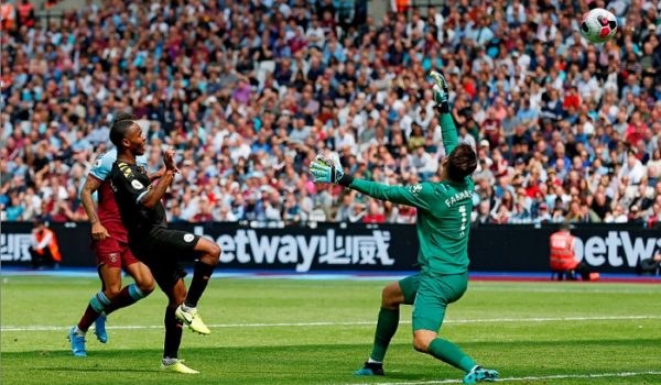 Raheem Sterling manda el balón sobre el portero Lukasz Fabianski, para anotar su tercer gol del partido ganado por el Manchester City 5-0 frente al West Ham United, este sábado en la Premier League de Inglaterra. LA PRENSA/ AFP/ Ian KINGTON