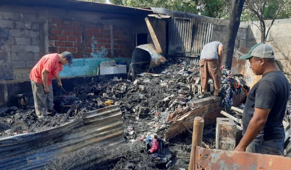 Tres hombres hurgan entre los escombros de la casa de Haydeli Araica que tomó fuego la madrugada del martes. LA PRENSA.