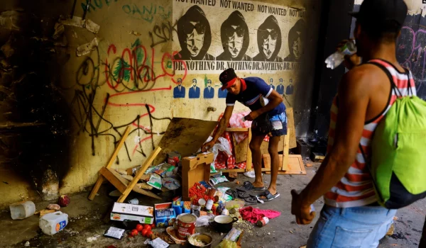 Migrantes se paran cerca de alimentos dañados después de que los migrantes, que intentaban llegar a EEUU, fueran atacados por personas desconocidas mientras se encontraban en un edificio abandonado donde viven, en el centro de Ciudad Juárez, México, el 17 de abril de 2023.