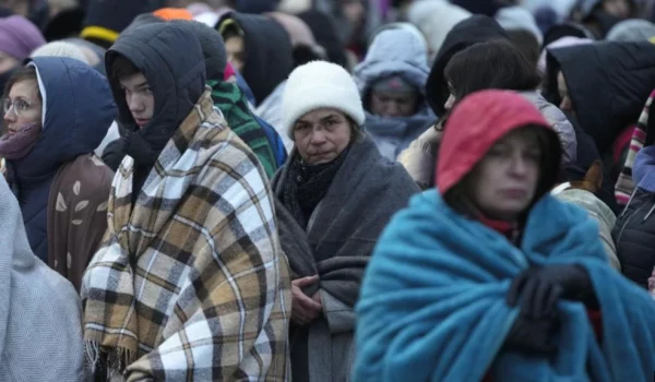 ARCHIVO - Refugiados, en su mayoría mujeres y niños, esperan con otras personas para ser trasladados después de llegar al cruce fronterizo de Medyka en Polonia, huyendo de la guerra en Ucrania, el 7 de marzo de 2022. (AP Photo/Markus Schreiber, File)