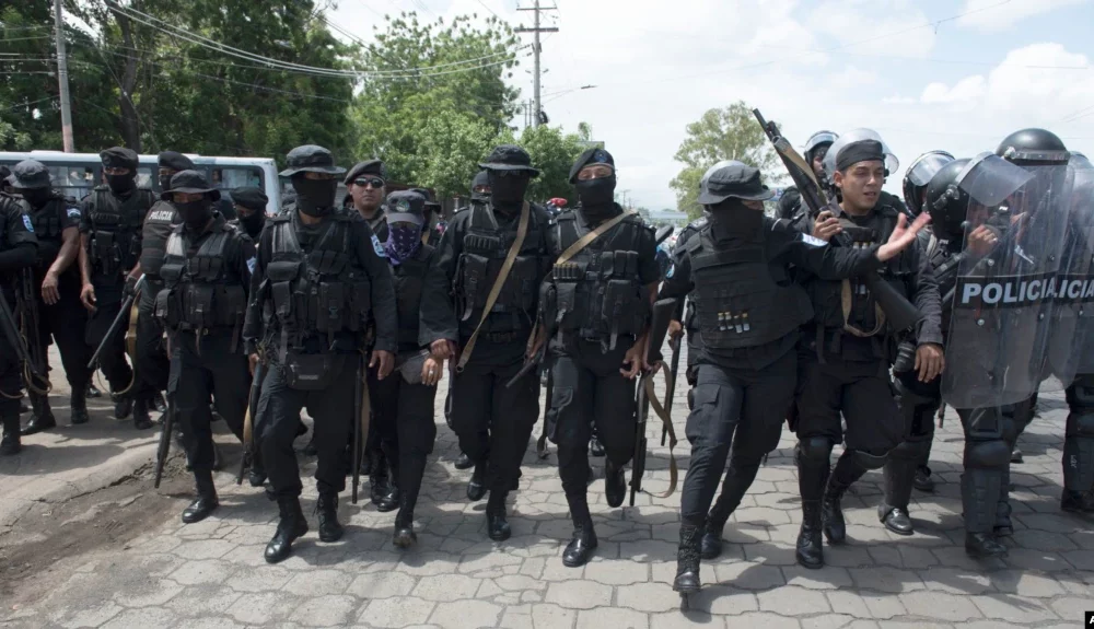ARCHIVO - Policías persiguen a manifestantes en Managua, Nicaragua, en abril de 2018.