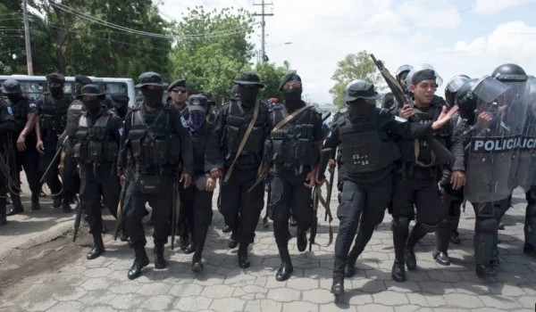 ARCHIVO - Policías persiguen a manifestantes en Managua, Nicaragua, en abril de 2018.