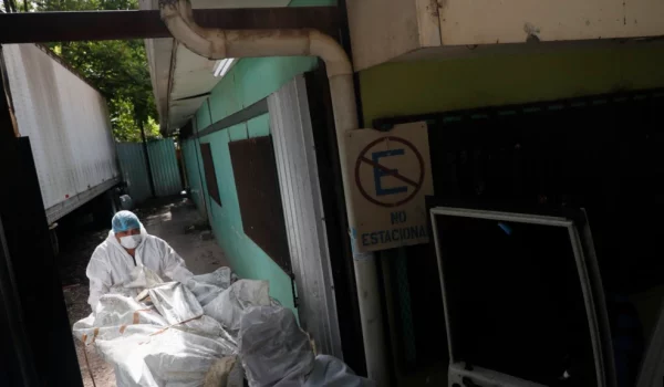 Expertos forenses descargan un cuerpo extraído de una prisión de mujeres en la morgue médica en Tegucigalpa, Honduras, el miércoles 21 de junio de 2023.