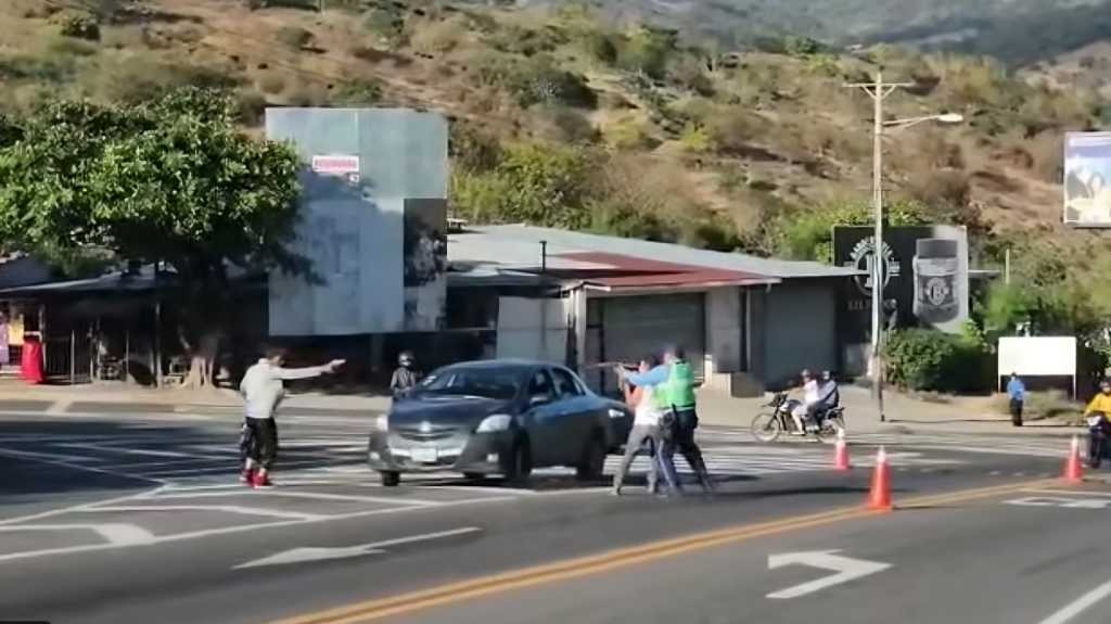 En la captura de imagen del video se observa el momento en que pistola en mano un hombre se enfrenta al agente del tránsito. LA PRENSA/ Captura de video