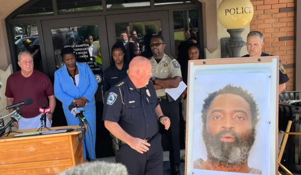 En esta foto tuiteada por Steve Gehlbach de WSB-TV, el jefe de Policía de Hampton, James Turner, en el centro, junto a una foto montada del sospechoso Andre Longmore durante una conferencia de prensa en Hampton, Georgia, el sábado 15 de julio de 2023.