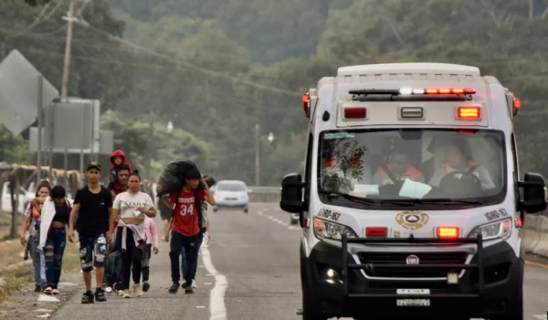 Una ambulancia pasa junto a migrantes que caminan hacia Huehuetán, estado de Chiapas, México, el lunes 24 de abril de 2023.