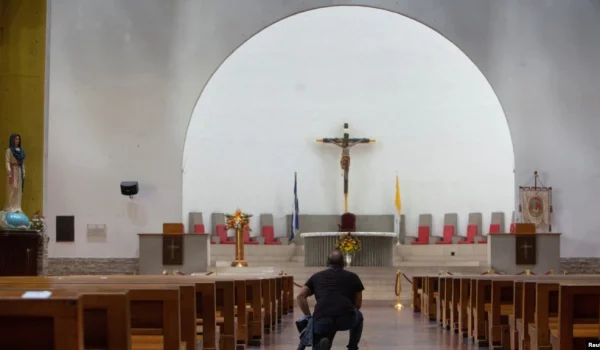 ARCHIVO: Un hombre se arrodilla en la Catedral Metropolitana de la Inmaculada Concepción de María cuando la policía nicaragüense prohibió una procesión y peregrinación católica en la capital, citando razones de seguridad interna, en Managua, Nicaragua, el 12 de agosto de 2022.