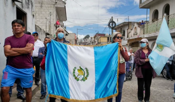 Simpatizantes llevan una bandera de Guatemala mientras escuchan al candidato presidencial Bernardo Arévalo durante un acto de campaña, el domingo 16 de julio de 2023, en Santa María de Jesús, Guatemala.