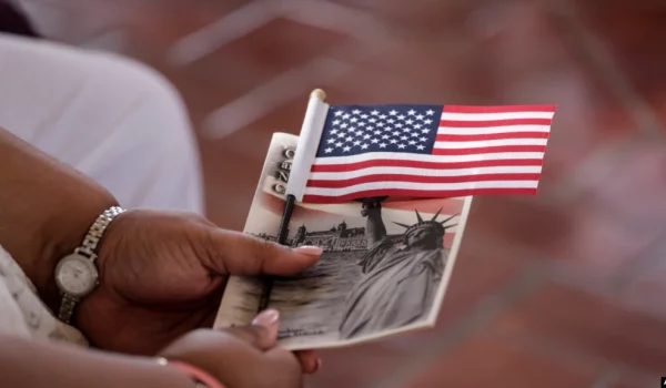 ARCHIVO - Una mujer sostiene una bandera estadounidense antes de convertirse en ciudadana ceremonia especial de naturalización en honor al Día de la Ciudadanía en Nueva York en septiembre de 2016.