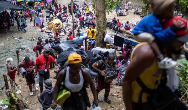 Familias inmigrantes, en su mayoría de Haití, salen de una parada de descanso para subir una montaña en el Tapón del Darién, cerca de la frontera de Colombia con Panamá. (Archivo: 19 de octubre de 2021)