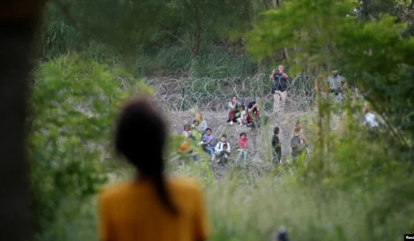 La venezolana Nathaly, de 13 años, observa a agentes de la Patrulla Fronteriza de EEUU devuelven a un grupo de migrantes a México, mientras ella y su familia intentan obtener una cita en la app CBP One desde un campamento improvisado en Matamoros, México, 21 de junio de 2023.