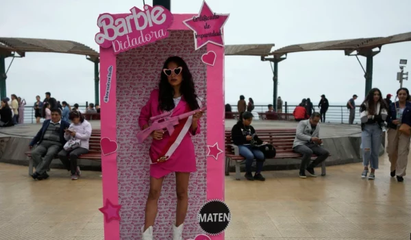 Una manifestante antigubernamental en Perú disfrazada de "Barbie Dictadora" sostiene un fusil de asalto de juguete durante una protesta contra la presidenta Dina Boluarte en Lima el 22 de julio de 2023.