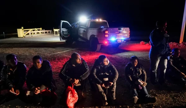 ARCHIVO: Migrantes esperan para ser procesados cerca de Yuma, Arizona, EEUU, el 6 de enero de 2023.