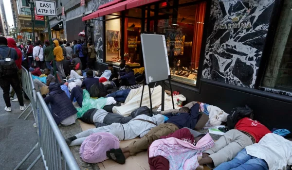 Cientos de migrantes permanecen día y noche afuera del hotel Roosevelt de Nueva York en espera que les asignen una cama, el 1 de agosto de 2023
