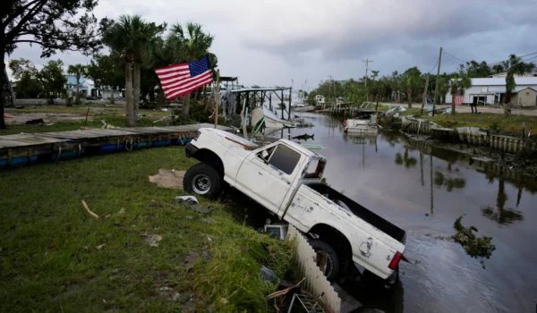 Una camioneta con una bandera estadounidense atada se encuentra a medio camino de un canal en Horseshoe Beach, Florida, después del paso del huracán Idalia, el 30 de agosto de 2023.
