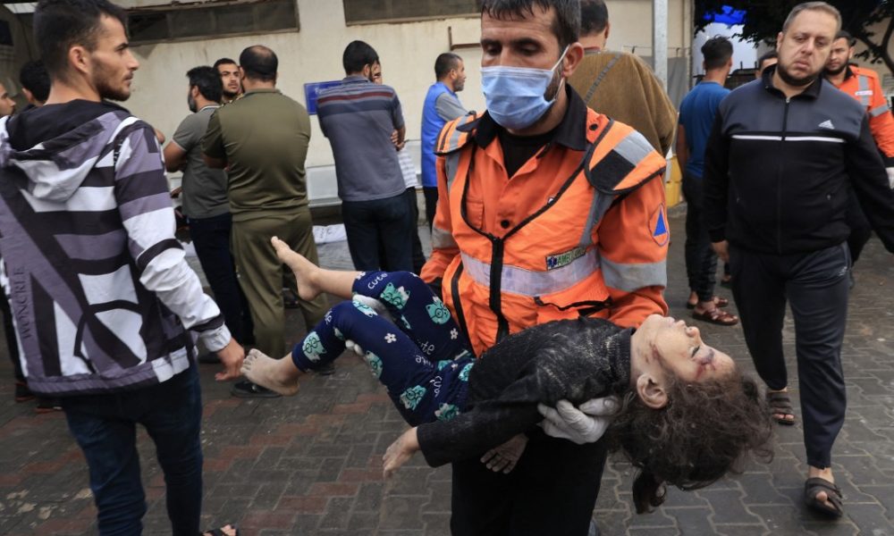 Un paramédico carga el cuerpo de una menor palestina que murió tras el bombardeo a un hospital en Gaza. LA PRENSA/AFP