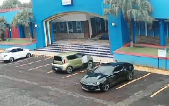 Uno de los maleantes rompe una de las ventanas de un carro estacionado en uno de los parqueos del Centro Comercial Managua. LA PRENSA/ Redes sociales/  Captura de video  