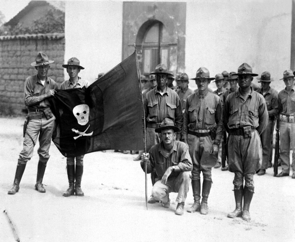 Marines de Estados Unidos exhiben una bandera roja y negra con una calavera y un cruce de un machete y un fusil, que pertenecía a las tropas de Sandino. LA PRENSA/ARCHIVO