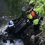 El bus extraurbano cayó la madrugada de este lunes por el puente de Belice, al norte de Ciudad de Guatemala, quedando parcialmente sumergido en un río. Foto: AFP