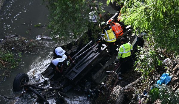 El bus extraurbano cayó la madrugada de este lunes por el puente de Belice, al norte de Ciudad de Guatemala, quedando parcialmente sumergido en un río. Foto: AFP