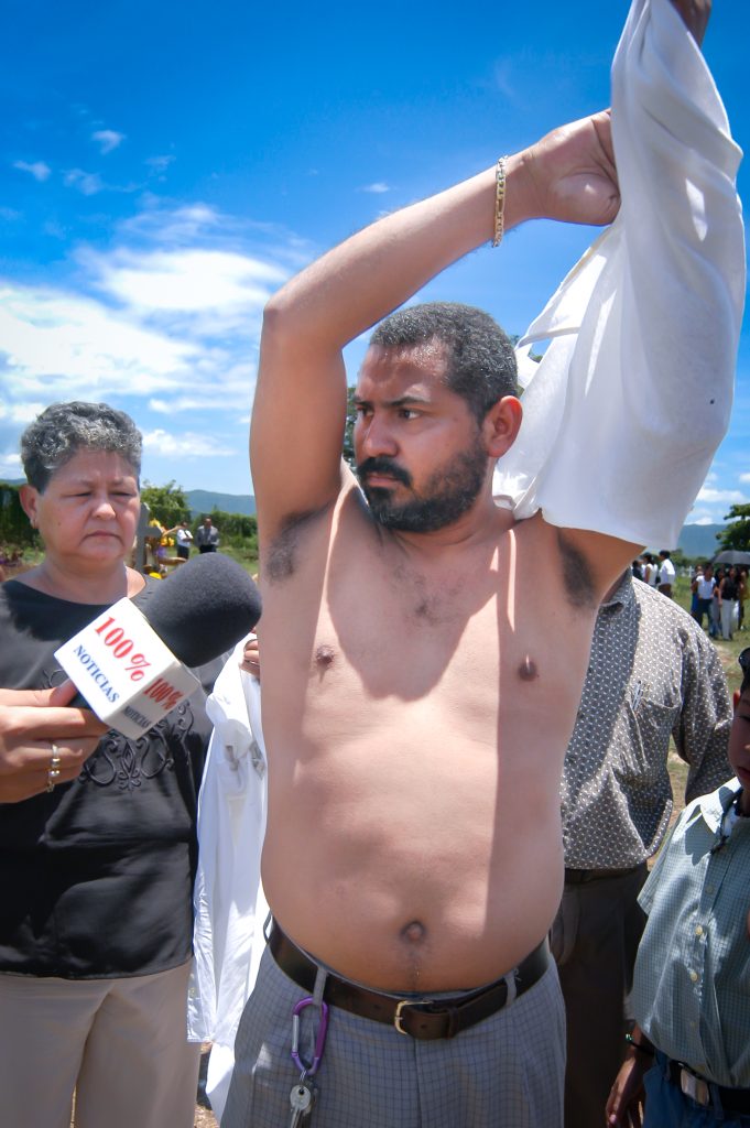 Tras el entierro, el juez Néstor Herrera se quita la camisa frente a periodistas para mostrar que no tenía rasguños ni moretones, intentando demostrar su inocencia. LA PRENSA / ARCHIVO PERSONAL ÓSCAR NAVARRETE