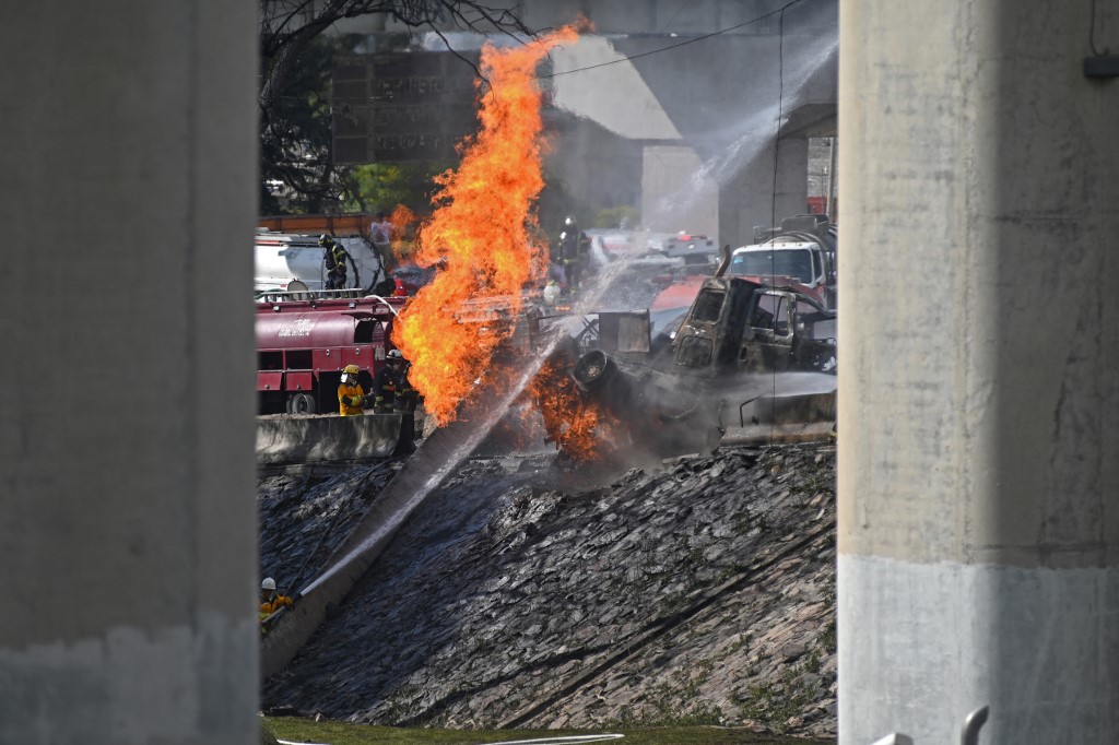 Bomberos apagando incendio en lo que fue la explosión de un camión en ciudad de México