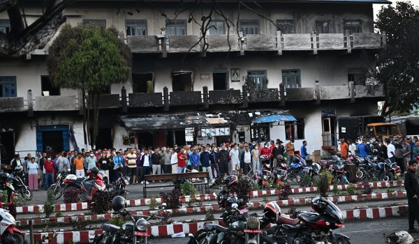 Personas en una calle durante el toque de queda impuesto para restablecer el orden público en Katmandú, Nepal. (Foto de Pedro Pardo / AFP)