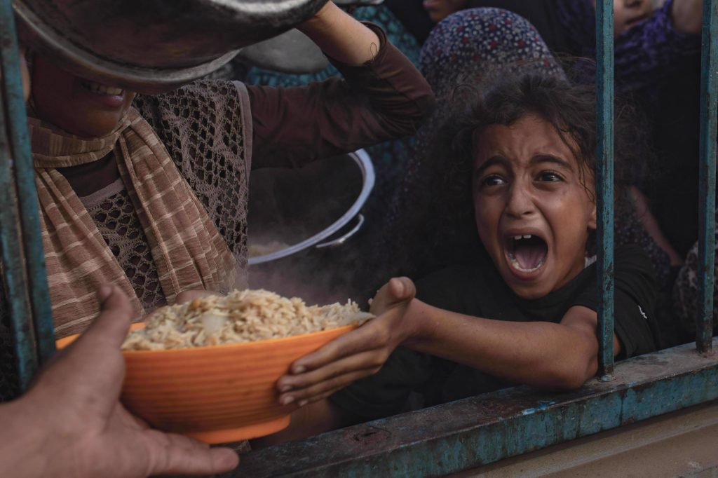 Niña palestina recibe comida en Gaza, la desesperación se nota en su rostro