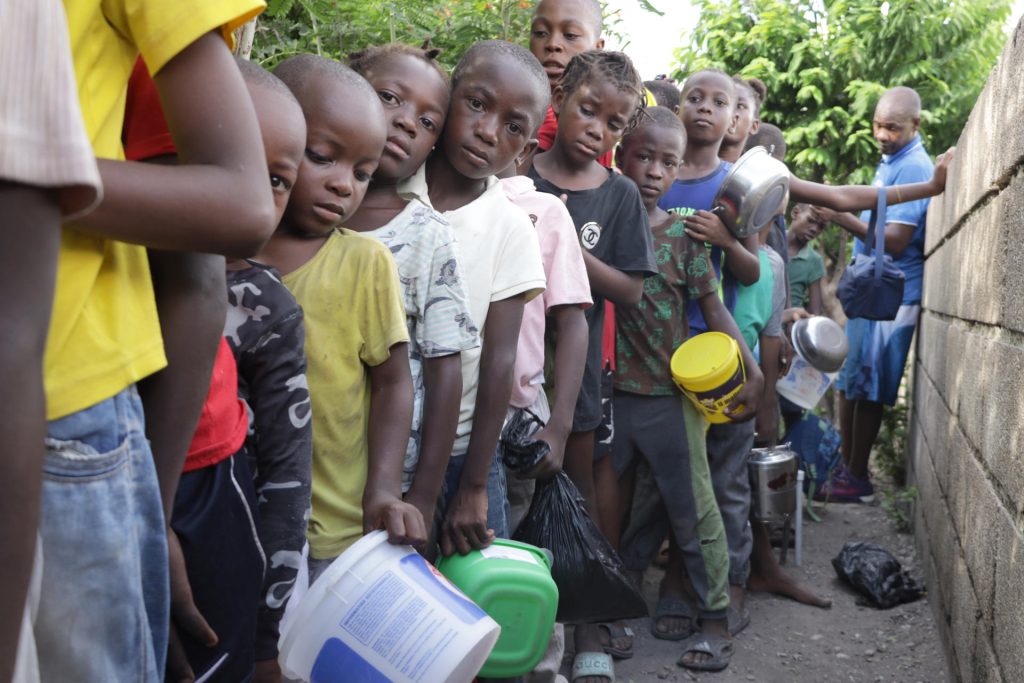Niños hacen fila para recibir comida 