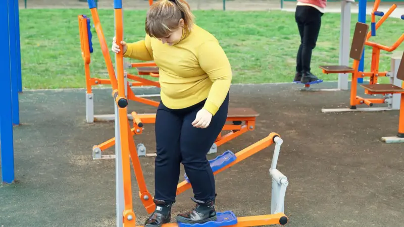 Niña con obesidad jugando en un parque