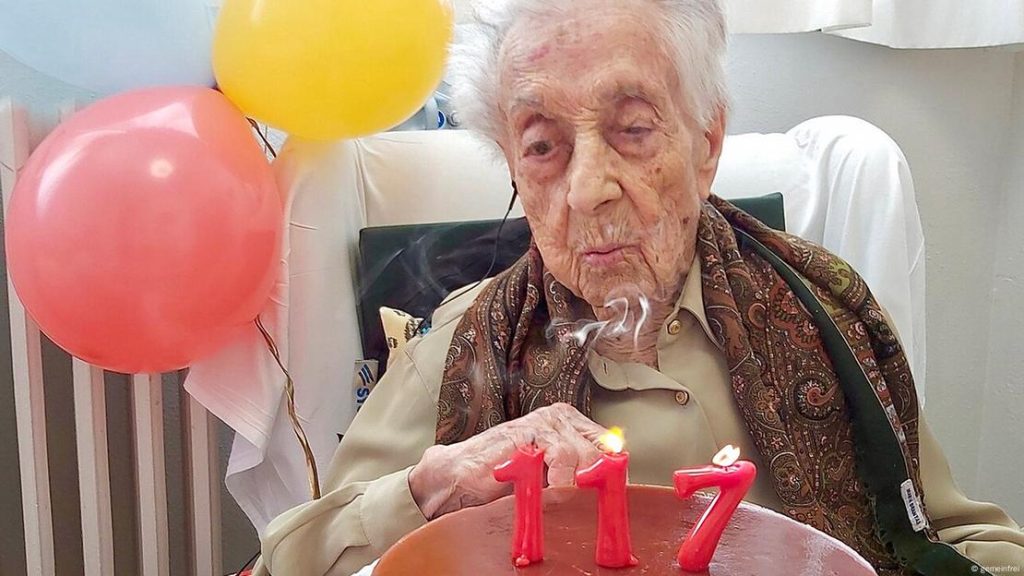 Señora cumpliendo 117 años con pastel de cumpleaños