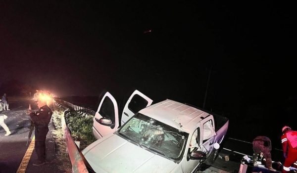 La camioneta blanca en la que viajaban los civiles, y al fondo los paramédicos de la Cruz Roja brindándole los primeros auxilios a los lesionados. FOTO: Tomada de redes sociales.