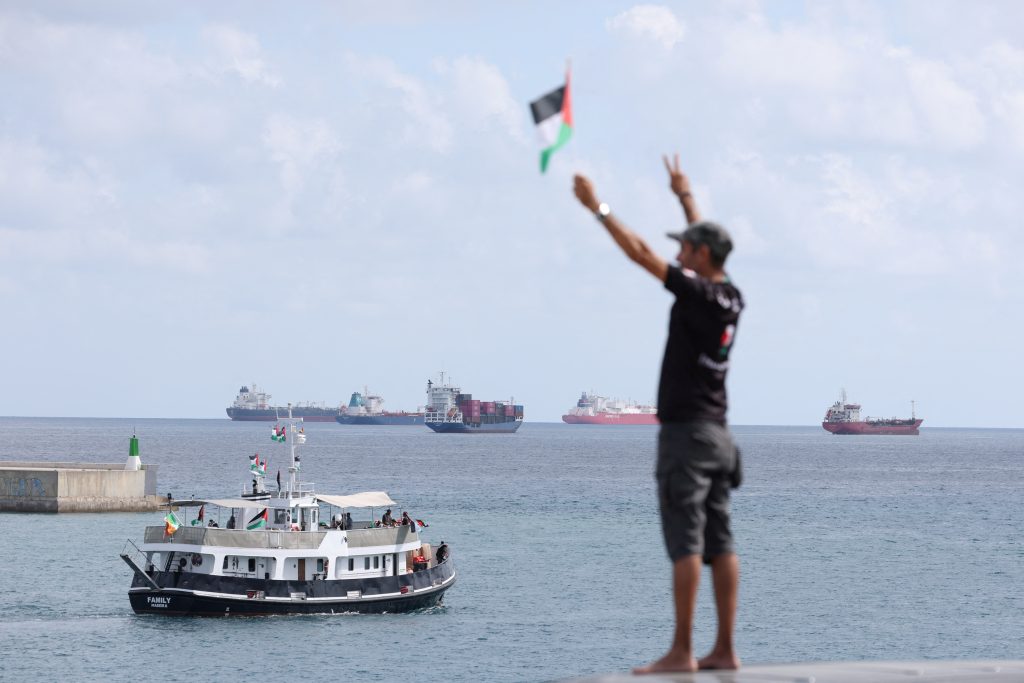 (ARCHIVOS) Un activista ondea la bandera palestina mientras un barco parte de una flotilla civil que busca romper el bloqueo israelí de la Franja de Gaza. (Foto de Lluis GENE / AFP)