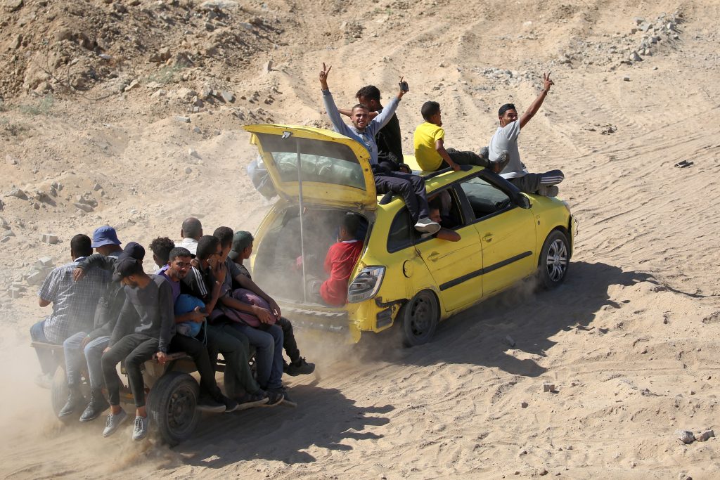 Un vehículo que remolca otro carro con pasajeros, avanzando por un camino de tierra hacia la ciudad de Gaza, cerca de Nuseirat, en el centro de la Franja de Gaza. (Foto de Eyad BABA / AFP)