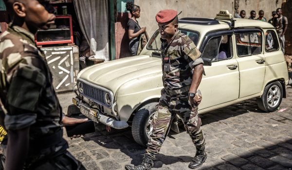 Miembros de la unidad CAPSAT del Ejército de Madagascar caminan junto a un viejo taxi cerca de la base CAPSAT, un día después de que la unidad anunciara que asumiría el poder. Foto: AFP