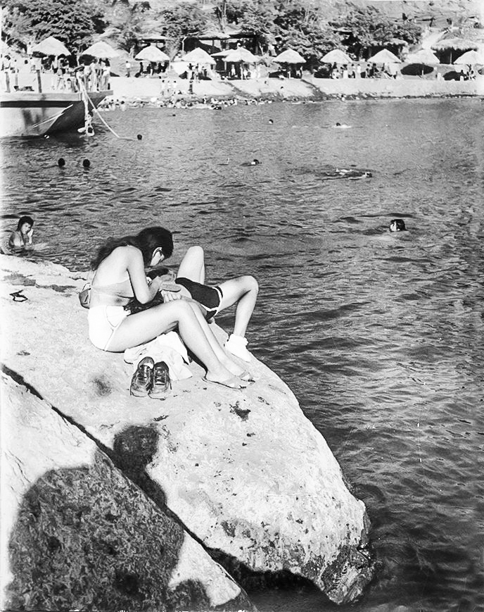Una pareja disfruta del sol de verano, mientras unos bañistas nadan en las frescas aguas de la laguna de Tiscapa. LA PRENSA / ARCHIVO