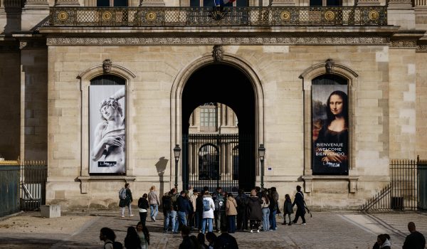 Los turistas reciben información del guía turístico frente a una entrada del patio cerrado de la pirámide del Louvre. (Foto de Dimitar DILKOFF / AFP)