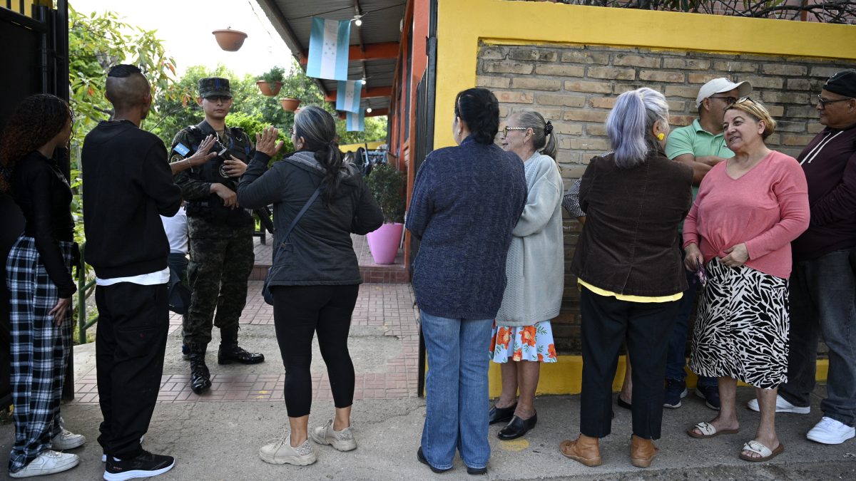 Personas hacen fila para votar en un centro de votación durante las elecciones generales en Tegucigalpa, el 30 de noviembre de 2025. (Foto de Orlando SIERRA / AFP)