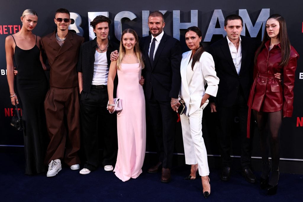 (ARCHIVOS) El exfutbolista inglés David Beckham (5.º por la izq.) y su esposa Victoria Beckham (3.ª por der.) posan en la alfombra roja con sus hijos y parejas. (Foto de HENRY NICHOLLS / AFP)