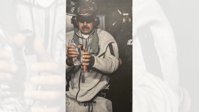 Maduro esposado y con los ojos tapados, de ropa deportiva gris y con una botella de plástico transparente en una de sus manos