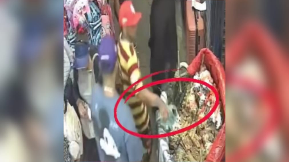 Sujeto echa líquido oscuro a un perol de vaho en el Mercado Oriental. Foto: captura de video del Canal 13.