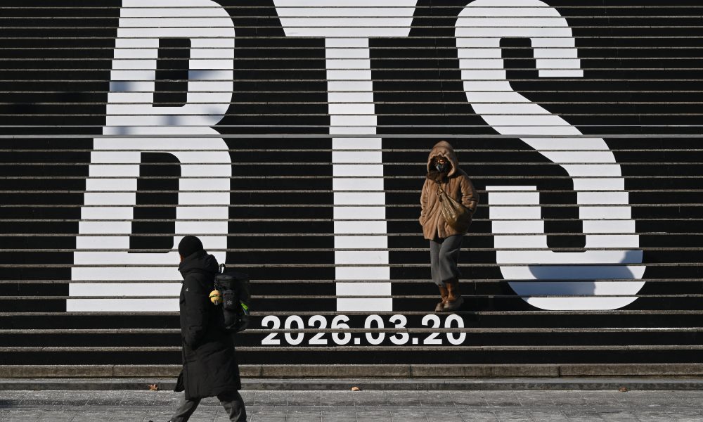 ARCHIVOS) Peatones caminan por las escaleras con el logo de BTS y la fecha de lanzamiento de su álbum "2026" en la Plaza Gwanghwamun de Seúl. (Foto de Jung Yeon-je / AFP)