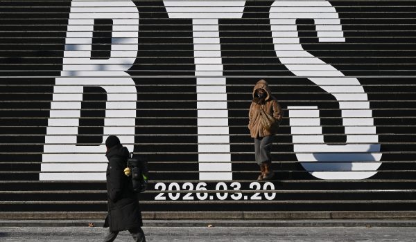 ARCHIVOS) Peatones caminan por las escaleras con el logo de BTS y la fecha de lanzamiento de su álbum "2026" en la Plaza Gwanghwamun de Seúl. (Foto de Jung Yeon-je / AFP)