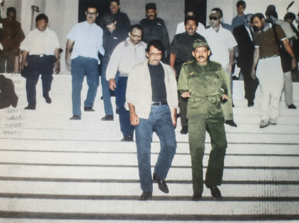 Daniel Ortega, presidente de Nicaragua, y su hermano Humberto Ortega, jefe del Ejército Sandinista, ministro de Defensa y jefe de la delegación del gobierno, junto a delegados, después de colocar una ofrenda floral en el monumento al Soldado de la Patria y partir hacia las negociaciones en Sapoá, el lunes 21 de marzo de 1988. LA PRENSA / FOTOGRAFÍA RESTAURADA CON IA