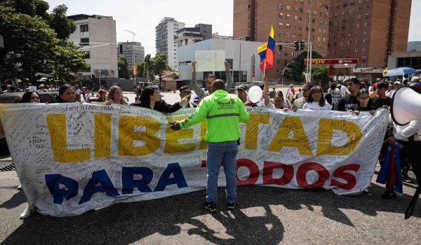 Un funcionario de la Policía Nacional Bolivariana bloquea el paso a familiares de presos políticos durante una protesta alrededor de El Helicoide. ARCHIVO/EFE/Ronald Peña R