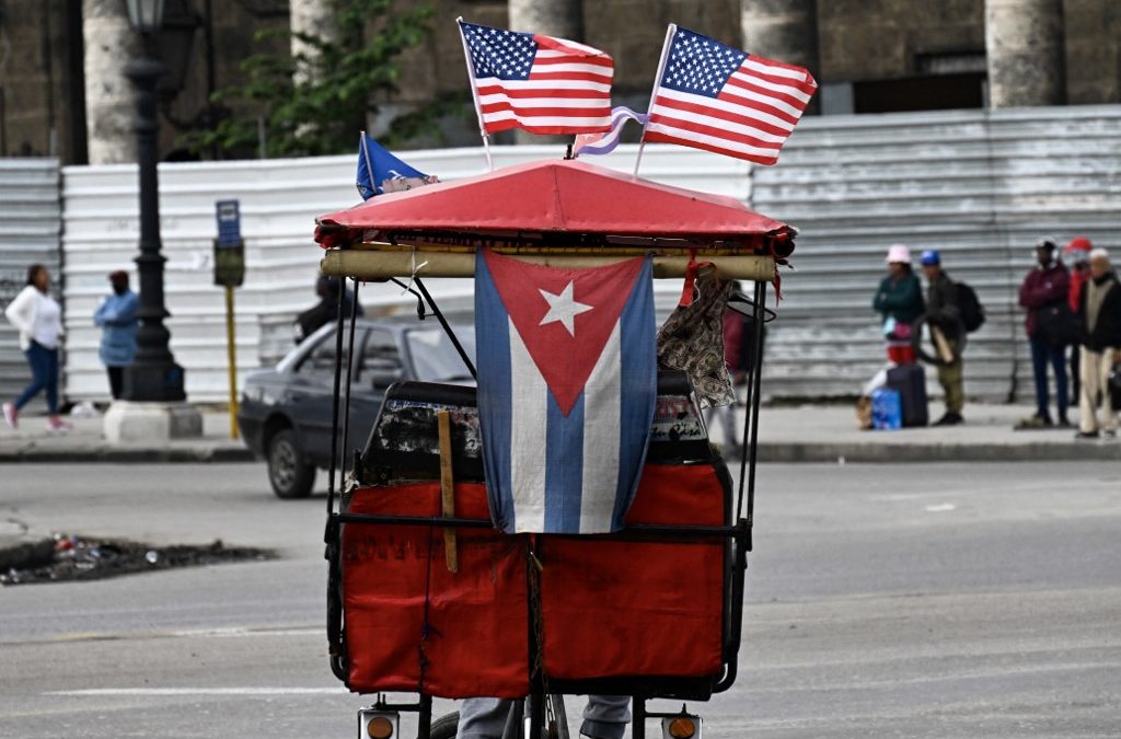 Un triciclo decorado con banderas de Cuba y Estados Unidos circula por las calles de La Habana. ARCHIVO/ YAMIL LAGE / AFP