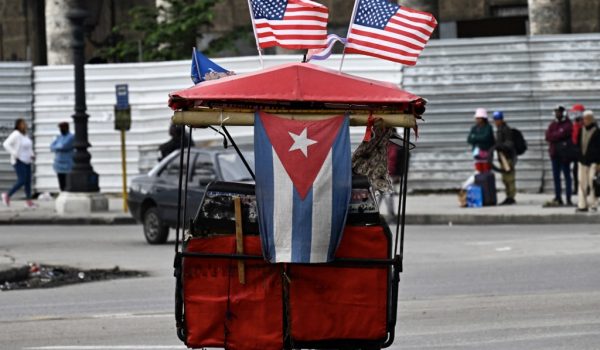 Un triciclo decorado con banderas de Cuba y Estados Unidos circula por las calles de La Habana. ARCHIVO/ YAMIL LAGE / AFP