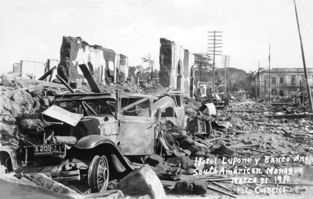 Autos destruidos en las afueras de lo que fue el hotel Lupone; al fondo, la parte sur del Palacio Nacional y parte del parque central. 